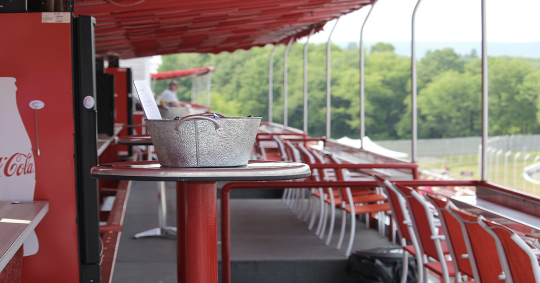 Red stools along the rail of the outdoor vista suite under its canopy